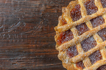 Close-up of a warm homemade Pasta Frola tart filled with quince. Argentinian Pastafrola Recipe on wooden table.
