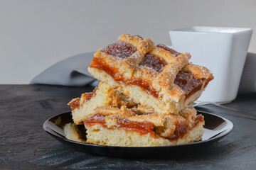 Quince cake on wooden table accompanied by cup.