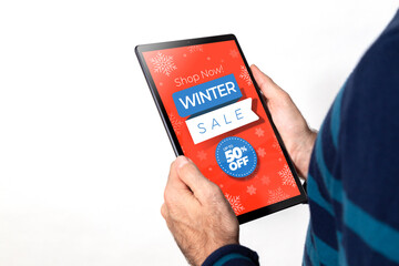 Winter sale offer on screen of tablet. Man holding a tablet with advertising on the screen. 50% discount. White background.