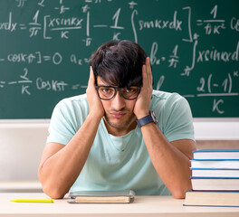 Young male student mathematician in front of chalkboard
