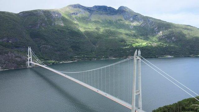 Hardanger Bridge - Aerial drone flying up over the fjord and bridge in Norway on a cloudy - 