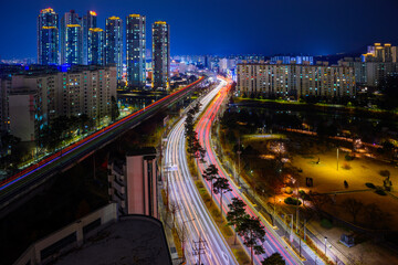 Chuncheon City night skyline, buildings, skyscrapers, illuminated light trails of metro subway railroad tracks and twelve lane highways in Gangwon-do Province, South Korea - obrazy, fototapety, plakaty