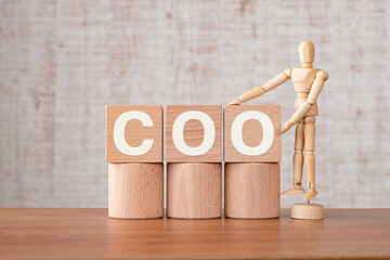There is wood cube with the word COO. It is an abbreviation for Chief Operating Officer as...
