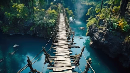 Deurstickers Old suspension bridge across river in jungle, perspective view of hanging vintage wooden footbridge. Scenery of tropical forest and water. Concept of travel, adventure, nature © scaliger