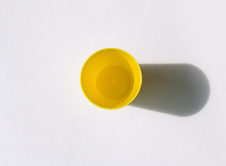 A yellow plastic cup on a white background.