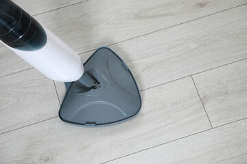 Cleaning floor with steam mop at home, top view. Space for text