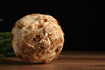 Fresh raw celery root on wooden table, closeup. Space for text