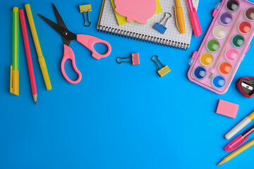 Flat lay composition with notebook and other school stationery on light blue background, space for text. Back to school