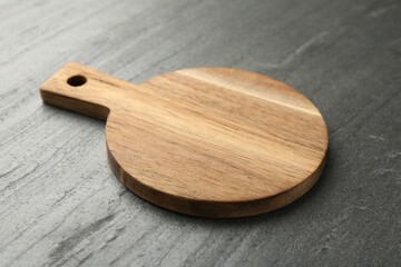 One wooden cutting board on dark grey table