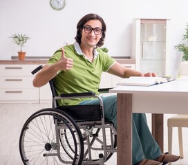 Young male student in wheelchair at home