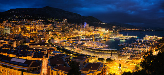 Aerial panorama of Monaco Monte Carlo harbour and illuminated city skyline in the evening blue hour twilight. Monaco Port night view with luxurious yachts - obrazy, fototapety, plakaty