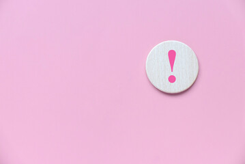 Wooden circle with exclamation mark over a pink background. - obrazy, fototapety, plakaty