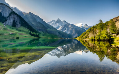 Fototapeta na wymiar Serene Symmetry, Majestic Peaks Mirrored in Tranquil Waters