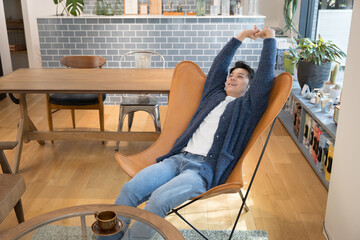 Fototapeta premium 部屋で伸びをしてリラックスする男性 全身