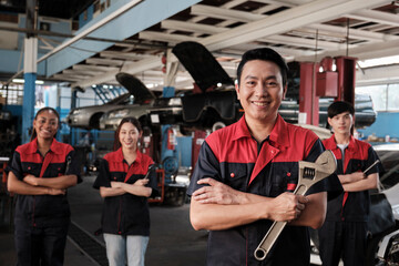 Portrait of professional workers team, male Asian supervisor arms crossed with fixing tools in...
