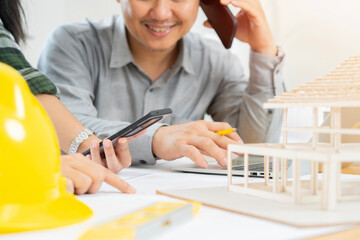 Business people working together on a building project, desktop side view with tools