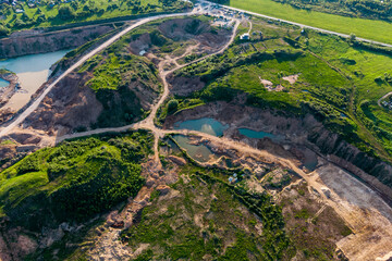 Aerial view of a sand quarry with overgrown slopes