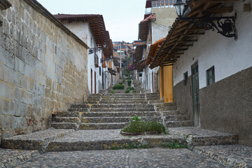 Traditional street in Cajamarca, characterized by a stone pavement and houses made of adobe with tile roofs.