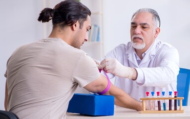 Obraz premium Young handsome man during blood test sampling procedure