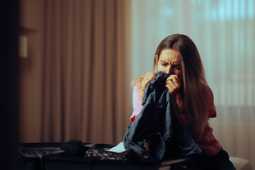 Sad Woman Smelling Boyfriend Clothes after a Break-up. Longing wife feeling grief and nostalgia after separation 
