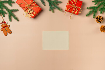 Flat lay composition with Christmas decor and blank card on beige background. Space for text