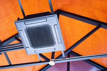 Black ceiling air conditioner. Close-up of cassette air conditioning system under steel structure...