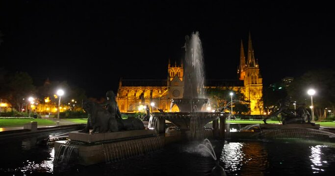 Beautiful ancient fountain and glowing cathedral at night - steady cam shot around