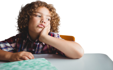 Digital png photo of bored caucasian boy sitting at table, hand on face on transparent background