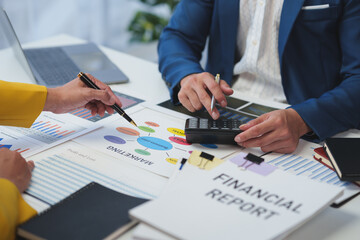 Two Asian businessmen discuss the working information of a financial investment project. Marketing and growth strategies and company revenue calculations Save data to a laptop computer in the office.