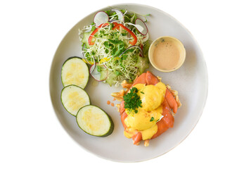 white plate with eggs bennedict waffles with smoked salmon on a white background