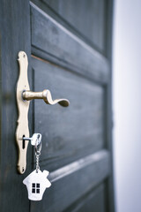door handle and key in the keyhole with house pendant. Ideal photo for real estate and financial advice propagation.