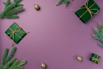 Christmas flat lay on a purple background with fir branch, balls and box