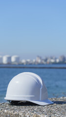 ヘルメットと海と工業地帯