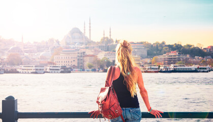 Fototapeta premium Young female tourist looking at Istanbul city panorama view at sunset- Travel, vacation or tour tourism in Turkey