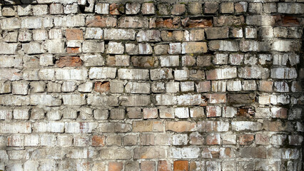 An old brick wall. The background is made of white and red shabby bricks. Dilapidated brick fence.