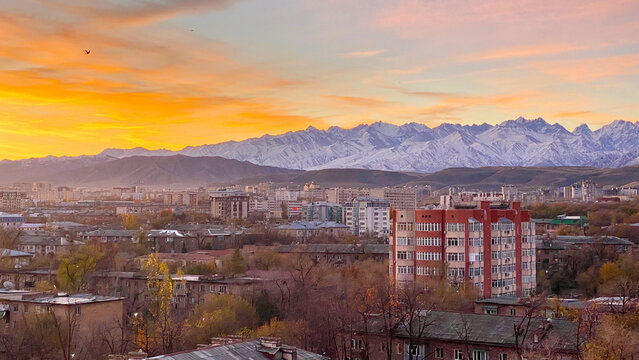 Stunning scenic sunrise in Bishkek city with views of mountain ranges and peaks. Autumn in Kyrgyzstan. Morning in the city.