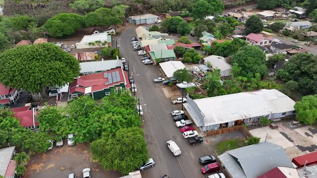 Aerial Kauai Hawaii Hanapepe city center traffic. Hanapepe River flows through historical town. Swinging suspension bridge sways as you cross it. Historically plantation style buildings.