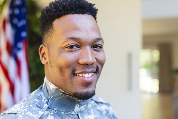 Happy african american male soldier face close up outside home with usa flag, copy space