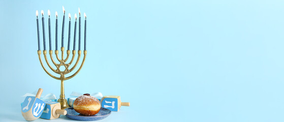 Hanukkiah with gifts, dreidels and donut on light blue background with space for text. Hanukkah...