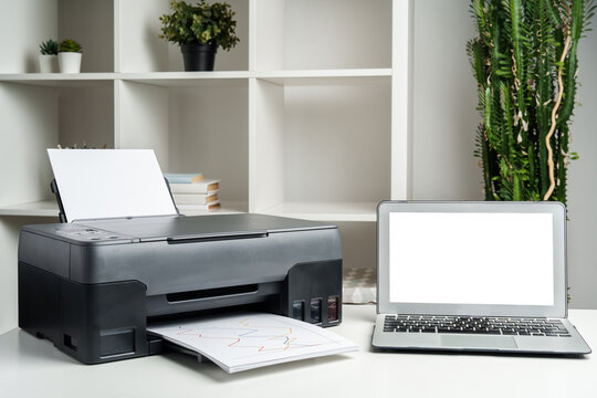 New modern printer and laptop in the office on table
