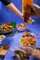 the hand holding mayonnaise bottle and rice blow in party and sharing concept