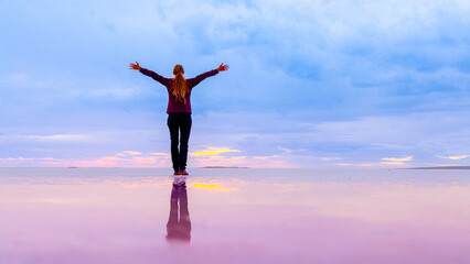 Fototapeta premium Woman standing with open arms in salt flats beach(Turkey, Ankara, salt lake, Tuz Golu)