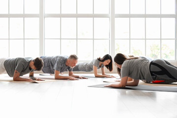 Group of sporty people doing plank in gym - obrazy, fototapety, plakaty