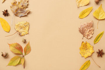 Frame made of beautiful autumn leaves on beige background