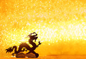 Silhouette of asian dragon on abstract light golden glittering background. lunar new year horoscope symbol. Chinese dragon - symbol of deity, wisdom, good start, Imperial power. element for design. - obrazy, fototapety, plakaty