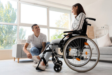 Young man and his wife in wheelchair at home