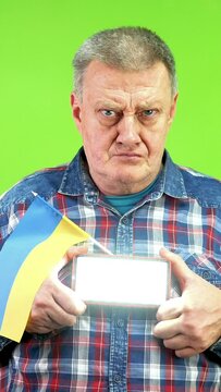 Mature man with ukrainian flag gives sos signal Morse code using flashlight.