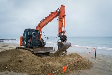 Bulldozer at work on a sandy beach. - obrazy, fototapety, plakaty
