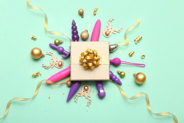 Gift box with sex toys and golden Christmas decor on turquoise background