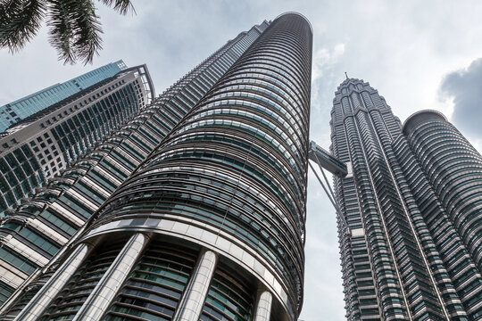 City skyline with Petronas Twin Towers under cloudy sky